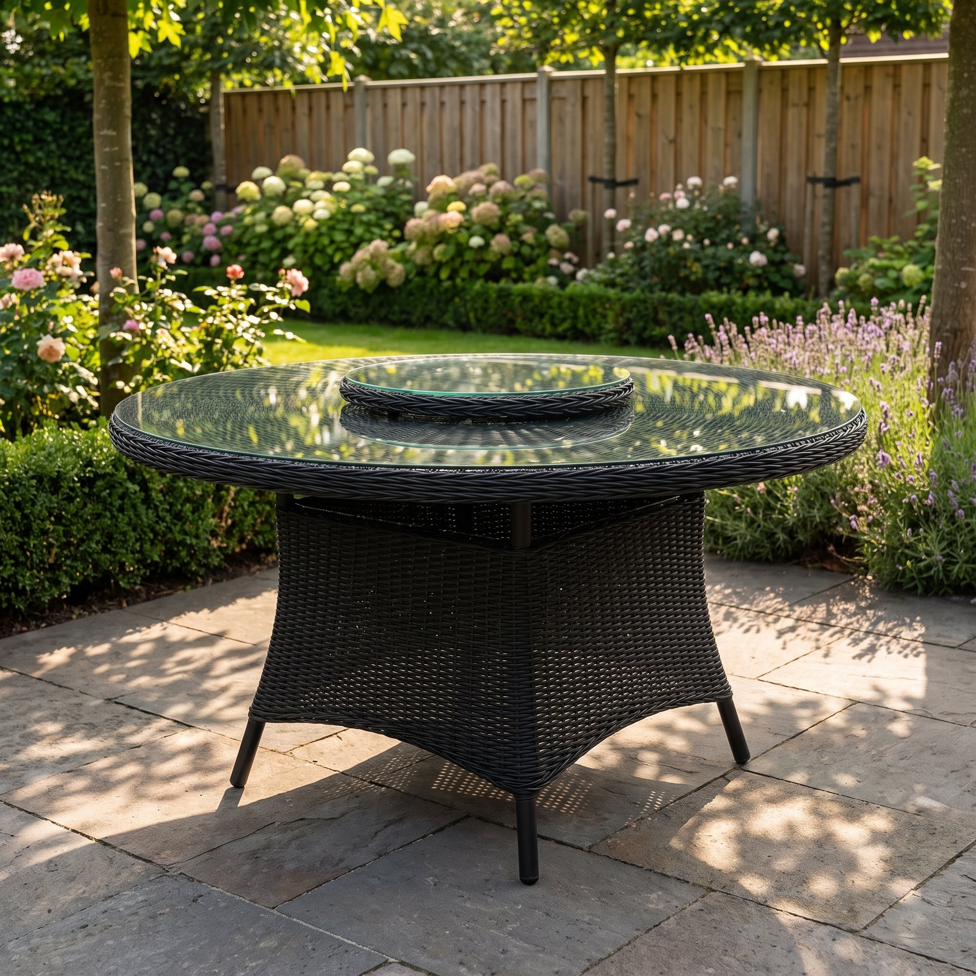 Rio Ronde Tuintafel 130 cm met glazen blad en bijna-zwart wicker in Rock Grey in een sfeervolle tuin - Outnest tuinmeubelen