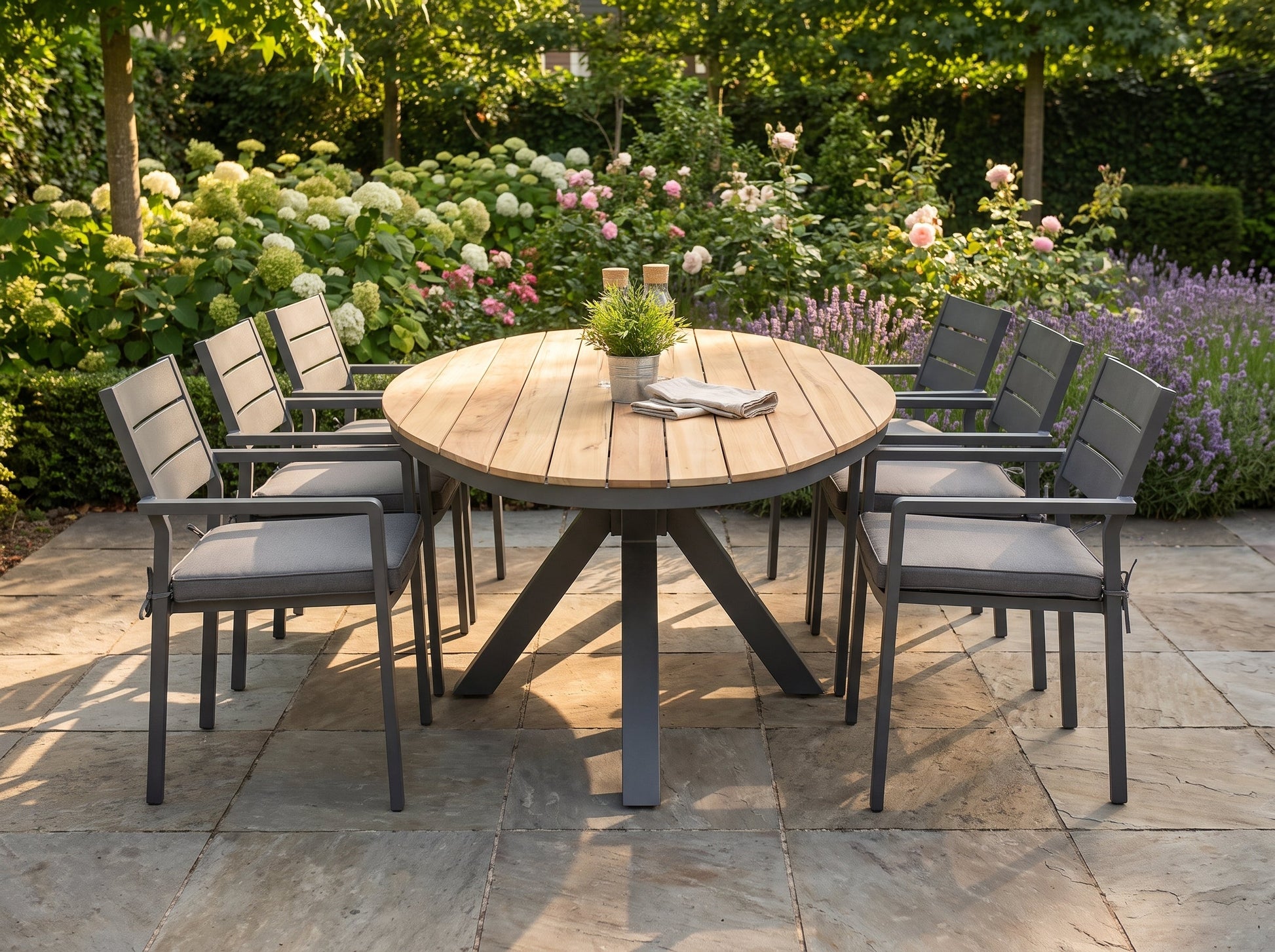 Akron-Bolton Tuinset 6 Personen - Teak / Dark Grey in een sfeervolle tuin - Outnest tuinmeubelen