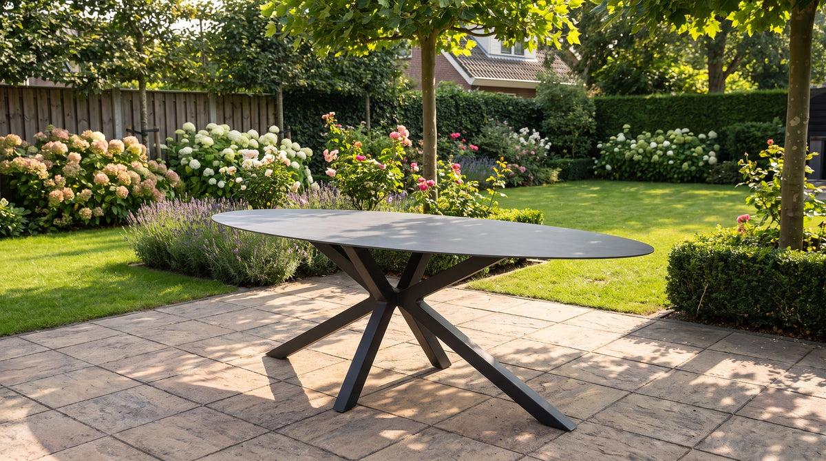 Ovale tuintafel gedekt voor de lunch op een zonnig terras