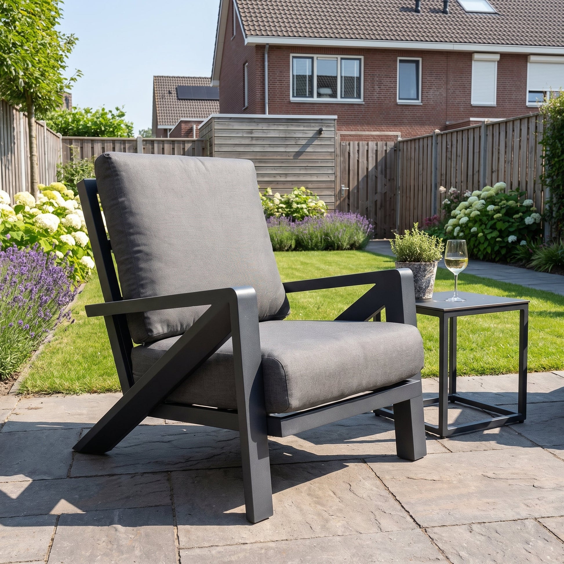 Carini Loungestoel - Black in een sfeervolle tuin - Outnest tuinmeubelen