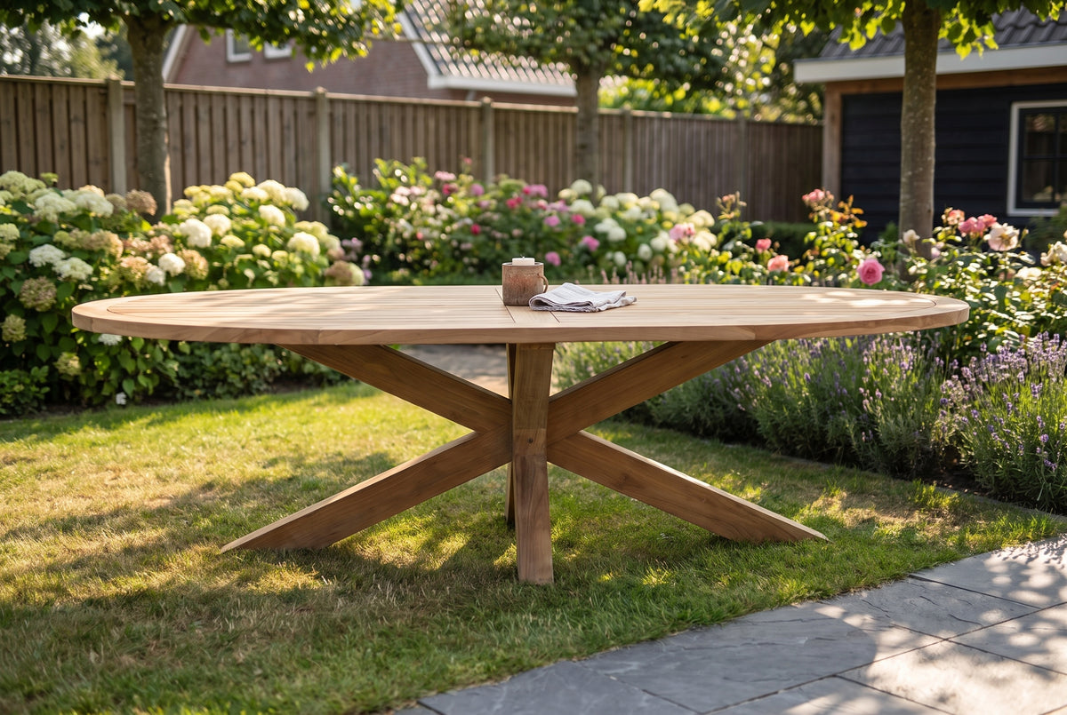 Teakhouten tuintafel in de vroege ochtend met een pot beits en een kwast ernaast op tafel