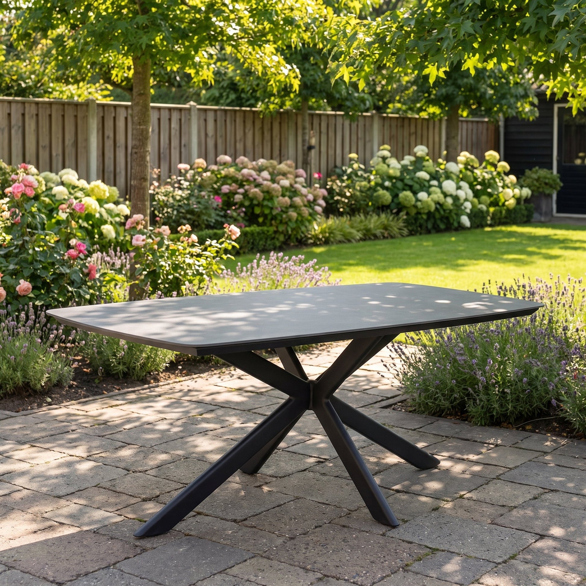 Egina Tuintafel 220 cm - Keramisch blad zwart in een sfeervolle tuin - Outnest tuinmeubelen