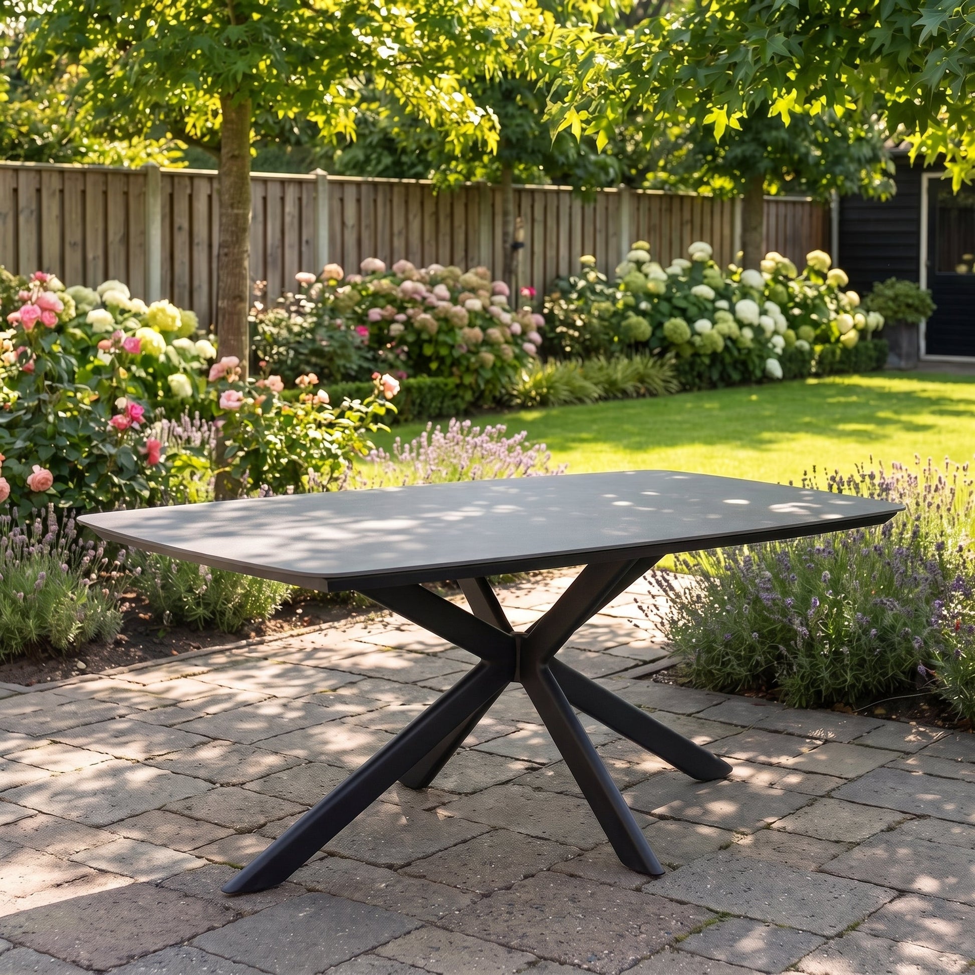 Egina Tuintafel 220 cm - Keramisch blad zwart in een sfeervolle tuin - Outnest tuinmeubelen