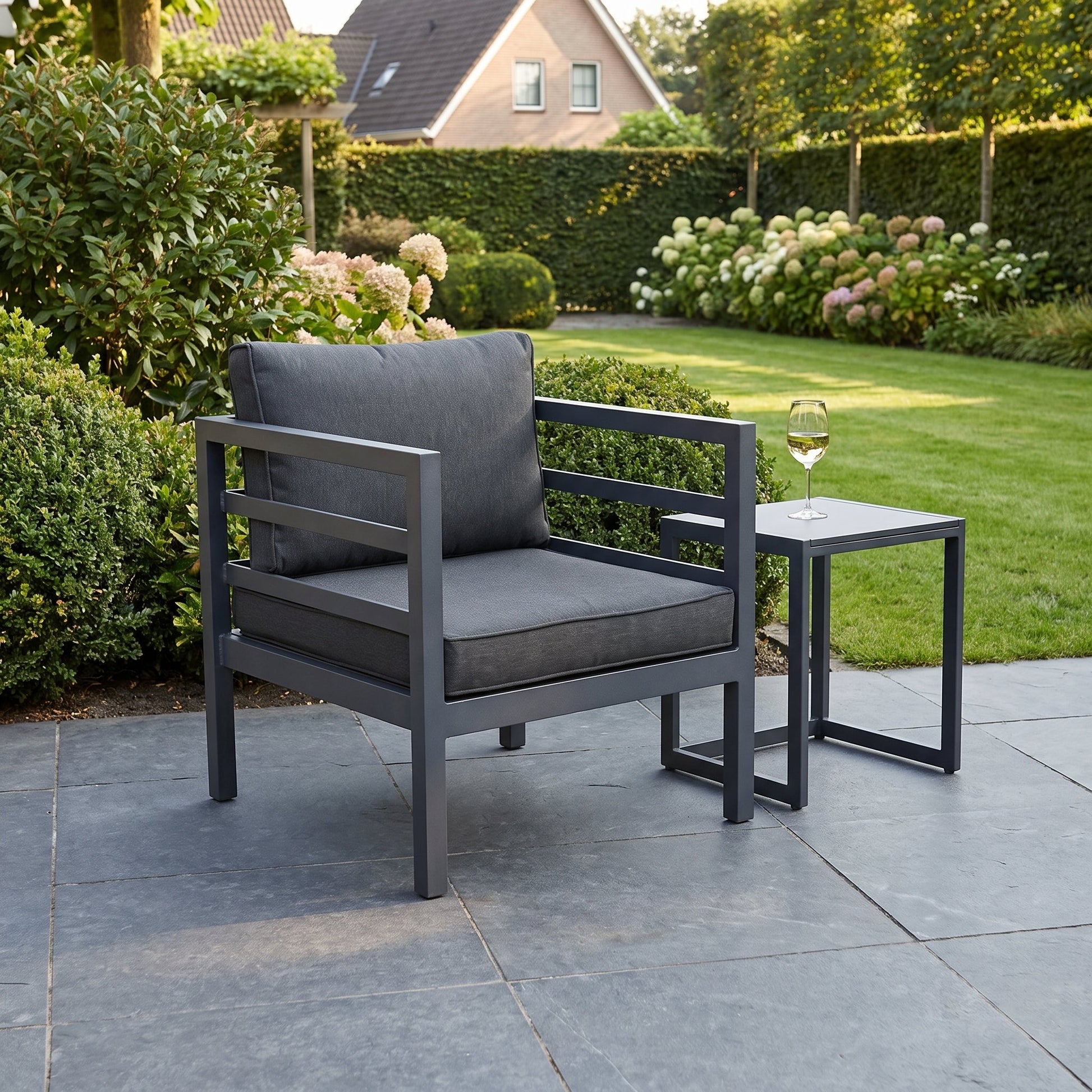 Nevada Loungestoel - Dark Grey in een sfeervolle tuin - Outnest tuinmeubelen
