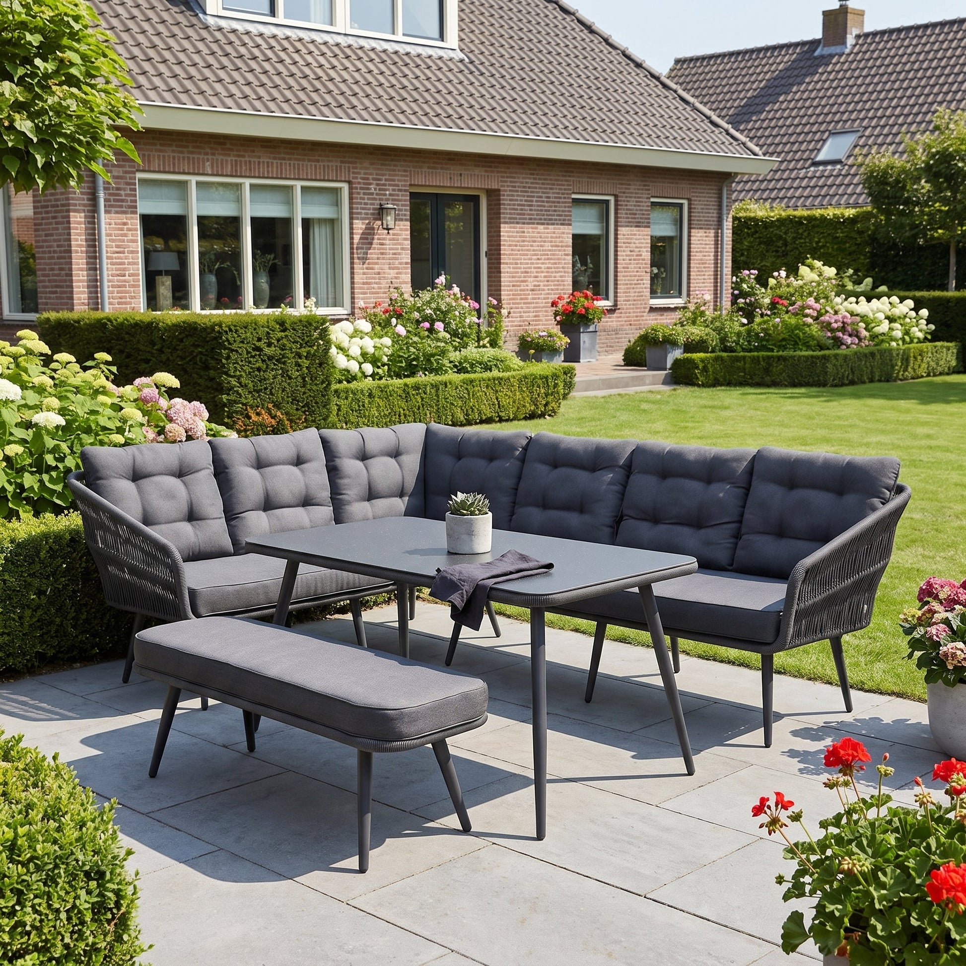 Positano Dining Loungeset - Anthracite (links) in een sfeervolle tuin - Outnest tuinmeubelen