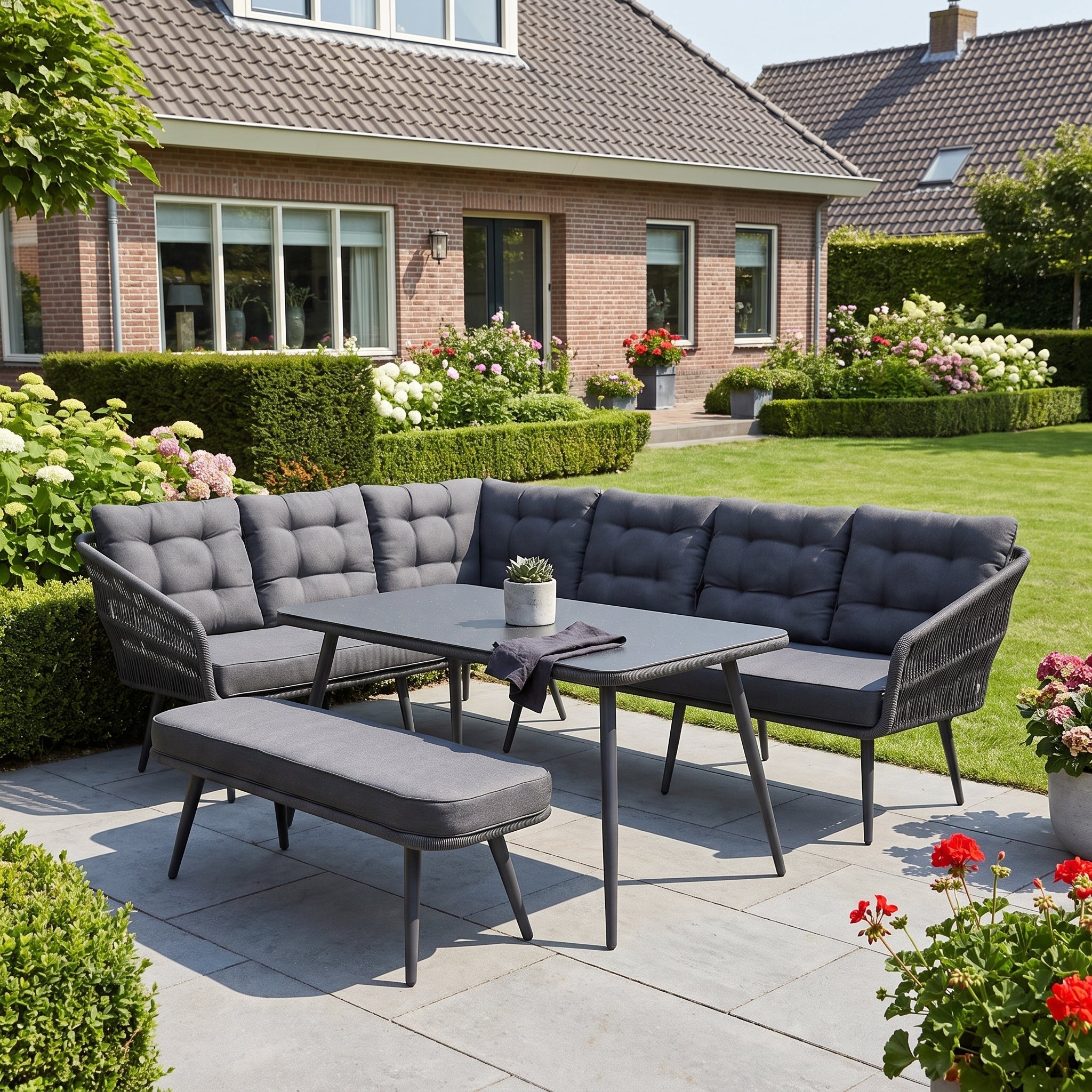 Positano Dining Loungeset - Anthracite (links) in een sfeervolle tuin - Outnest tuinmeubelen