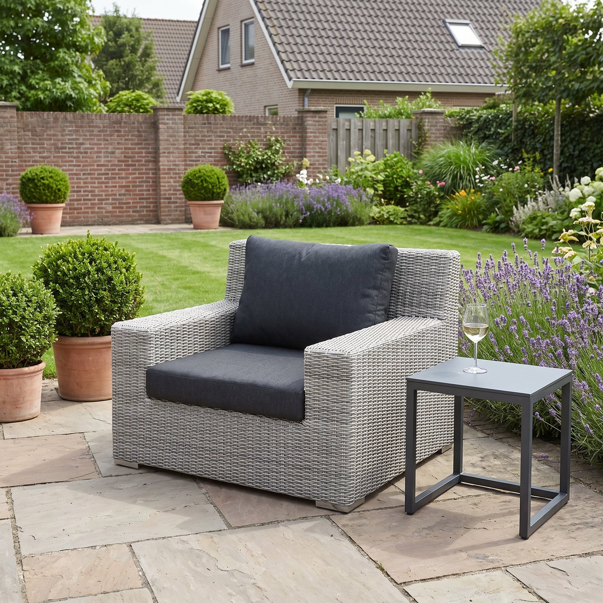 Riga Loungestoel - Light Kobo Grey in een sfeervolle tuin - Outnest tuinmeubelen